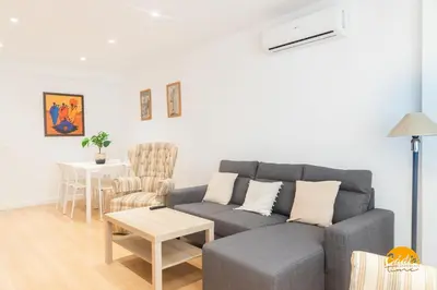 a living room with a gray couch and a table at Villa Lola by Cadiz Time in Cádiz