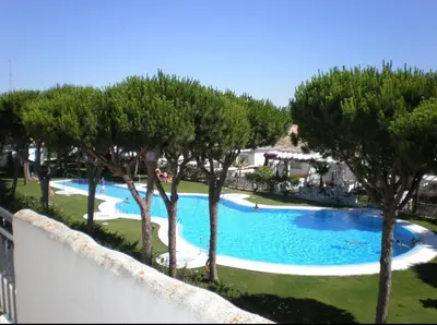 a view of a swimming pool with trees at Apartamento la Barrosa ,Urb los Veleros in Chiclana de la Frontera
