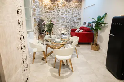 a dining room with a table and white chairs at innCádizCASA SEÑORIAL DE 1790 in Cádiz