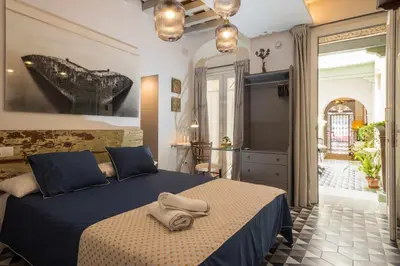 a bedroom with a bed with two towels on it at Casa Portus Gaditanus s XVIII Patio Andaluz in El Puerto de Santa María