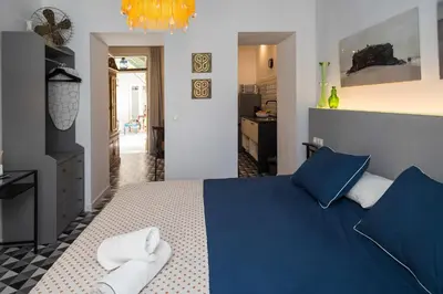 a bedroom with a blue bed with towels on it at Casa Portus Gaditanus s XVIII Patio Andaluz in El Puerto de Santa María