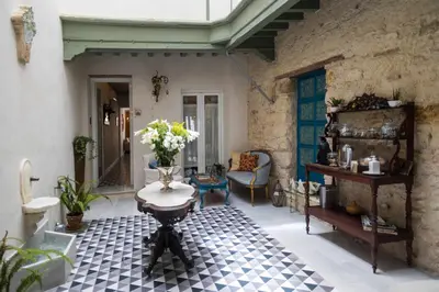a living room with a table and a couch at Casa Portus Gaditanus s XVIII Patio Andaluz in El Puerto de Santa María
