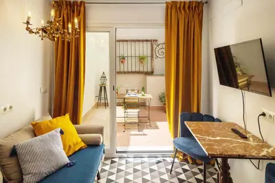 a living room with a blue couch and a table at Casa Portus Gaditanus s XVIII Patio Andaluz in El Puerto de Santa María