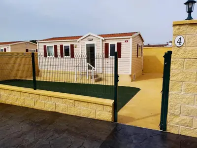 a fence in front of a house with a building at FINCA VILLA ZAAR HOMES in Puerto Real