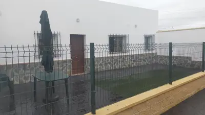 a fence with a table in front of a building at FINCA VILLA ZAAR HOMES in Puerto Real
