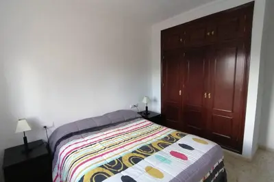 a bedroom with a bed and a wooden cabinet at CASA LAGO in Arcos de la Frontera