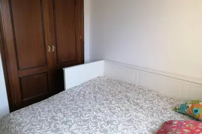 a small bedroom with a bed and a wooden cabinet at CASA LAGO in Arcos de la Frontera