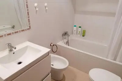 a white bathroom with a sink and a toilet at CASA LAGO in Arcos de la Frontera