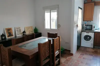 a kitchen with a dining table and a washing machine at CASA LAGO in Arcos de la Frontera