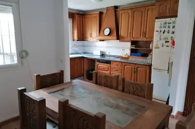 a kitchen with wooden cabinets and a wooden table at CASA LAGO in Arcos de la Frontera