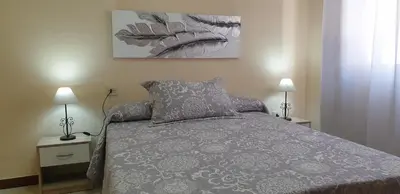 a bedroom with a bed and two lamps on tables at Casa Mercedes in Rota