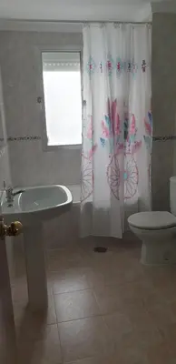 a bathroom with a toilet and a shower curtain at Casa Mercedes in Rota