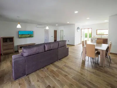 a living room with a couch and a dining room at Chalet Conil Ramirez in Conil de la Frontera