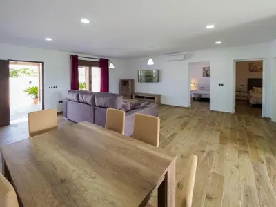 a living room with a wooden table and a couch at Chalet Conil Ramirez in Conil de la Frontera