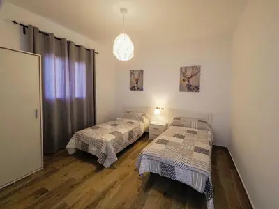a bedroom with two beds and a pendant light at Chalet Conil Ramirez in Conil de la Frontera