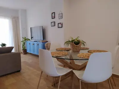 a dining room with a table and white chairs at AZAHAR-Playa Home by Cadiz4Rentals in Cádiz