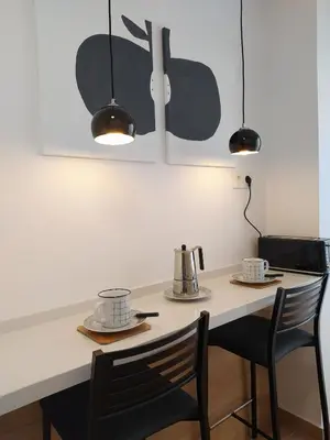 a kitchen with a table with two chairs and two lights at AZAHAR-Playa Home by Cadiz4Rentals in Cádiz