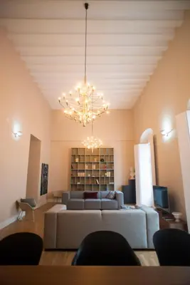 a living room with a couch and a chandelier at Casa Plaza de las Flores Cádiz Grupo AC Gestión in Cádiz