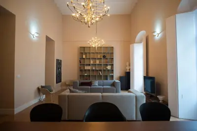 a living room with a couch and a chandelier at Casa Plaza de las Flores Cádiz Grupo AC Gestión in Cádiz