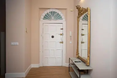 a hallway with a white door and a mirror at Casa Plaza de las Flores Cádiz Grupo AC Gestión in Cádiz