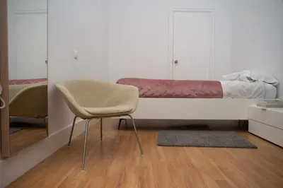a bedroom with a bed and a chair and a mirror at Casa Plaza de las Flores Cádiz Grupo AC Gestión in Cádiz