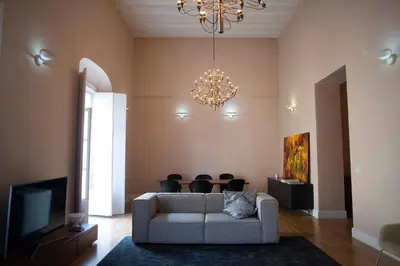 a cat sitting on a couch in a living room with a chandelier at Casa Plaza de las Flores Cádiz Grupo AC Gestión in Cádiz