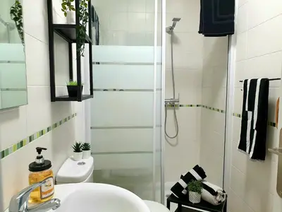 a bathroom with a glass shower and a sink at Sherryflat Jarana- Parking in Jerez de la Frontera
