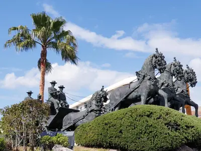 a statue of men on horses in front of a palm tree at Sherryflat Jarana- Parking in Jerez de la Frontera