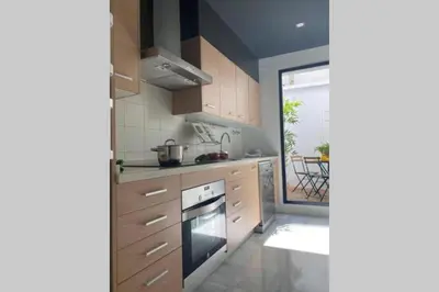 a kitchen with wooden cabinets and a stove top oven at Palacio Caballeros. Parking/Wifi in Jerez de la Frontera