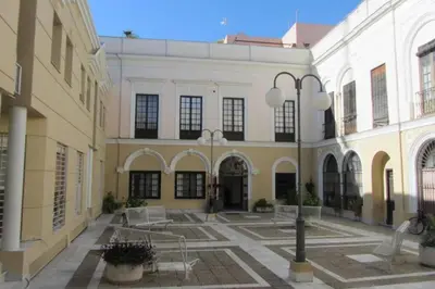 a courtyard of a building with tables and chairs at Palacio Caballeros. Parking/Wifi in Jerez de la Frontera