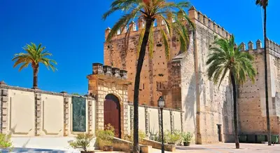 a large building with palm trees in front of it at Kiana Loft, La Casa del Parral in Jerez de la Frontera