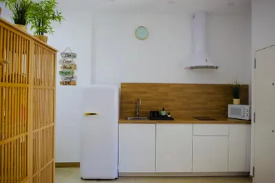 a kitchen with white cabinets and a white refrigerator at Loft CENTRO San Diego in Sanlúcar de Barrameda