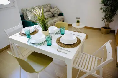 a white table with plates and dishes on it in a living room at Loft CENTRO San Diego in Sanlúcar de Barrameda