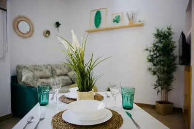 a dining room table with plates and glasses on it at Loft CENTRO San Diego in Sanlúcar de Barrameda