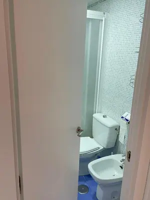 a bathroom with a white toilet and a sink at Azvalia - Valparaíso beach apartment - Piscina y parking gratis in El Puerto de Santa María