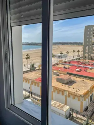 a window with a view of a beach and buildings at Azvalia - Valparaíso beach apartment - Piscina y parking gratis in El Puerto de Santa María