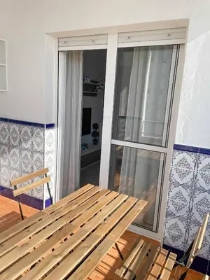 a wooden bench in a room with a window at Azvalia - Valparaíso beach apartment - Piscina y parking gratis in El Puerto de Santa María