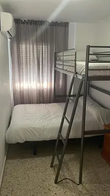 a bedroom with two bunk beds and a window at Azvalia - Valparaíso beach apartment - Piscina y parking gratis in El Puerto de Santa María