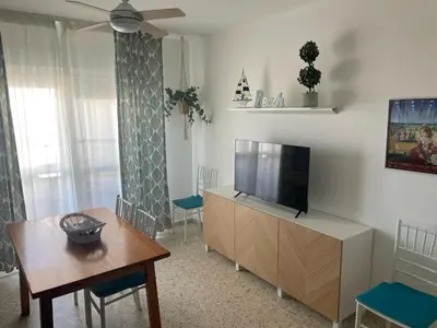 a living room with a flat screen tv and a table at Azvalia - Valparaíso beach apartment - Piscina y parking gratis in El Puerto de Santa María