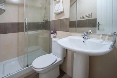 a bathroom with a toilet and a sink and a shower at Apartamento Garum in Cádiz