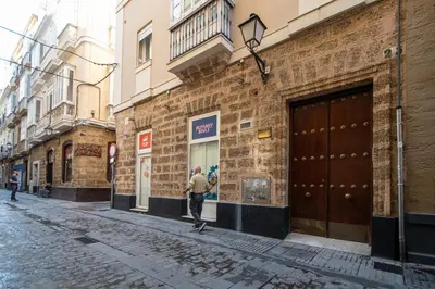 a man walking down a street next to a building at Apartamento Garum in Cádiz