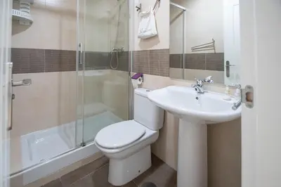 a bathroom with a toilet and a sink and a shower at Apartamento Garum in Cádiz