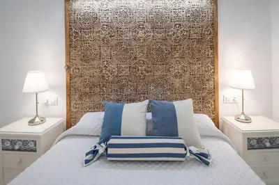 a bedroom with a bed with blue and white pillows at Apartamento Animalia in Cádiz