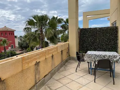 a patio with a table and chairs on a balcony at Playa las Redes in El Puerto de Santa María