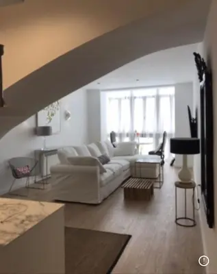 a living room with a white couch and a table at PLAZA CABILDO 4 in Sanlúcar de Barrameda