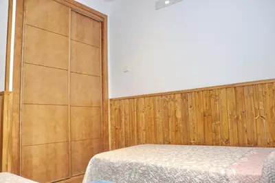 a bedroom with a bed and a large screen at Chalet Brenes Sol in Conil de la Frontera