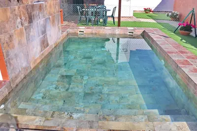 a swimming pool in a backyard with a table in it at Chalet Brenes Sol in Conil de la Frontera