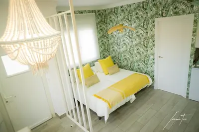 a bedroom with a bed with yellow pillows at R&B Puerto Sherry Beach in El Puerto de Santa María