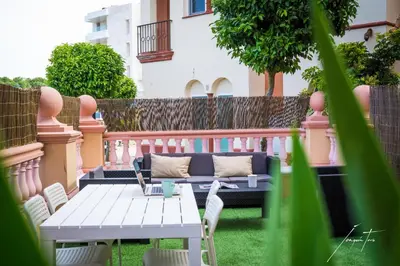 a patio with a couch and a table and chairs at R&B Puerto Sherry Beach in El Puerto de Santa María