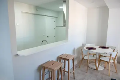 a bathroom with a table and two chairs and a mirror at El mirador de Ancha in Cádiz
